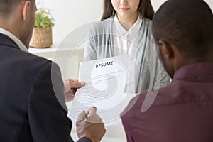 HR managers reading female employee resume in office