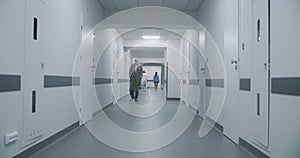 Multiracial medical staff walk clinic corridor
