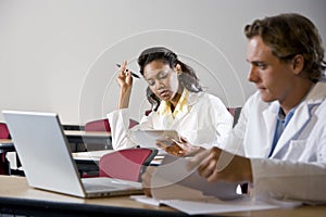 Multiracial medical students studying in classroom