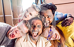 Multiracial millenial people taking selfie sticking out tongue with happy faces - Funny life style concept against racism