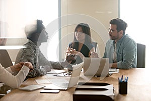 Multiracial millennial colleagues discuss ideas at briefing