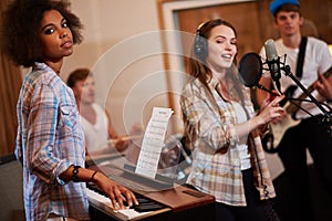 Multiracial music band performing in a recording studio