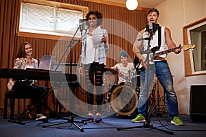 Multiracial music band performing in a recording studio