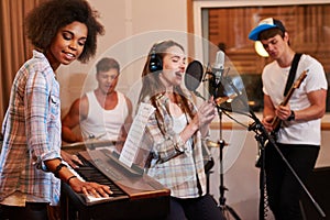 Multiracial music band performing in a recording studio