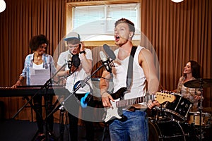 Multiracial music band performing in a recording studio