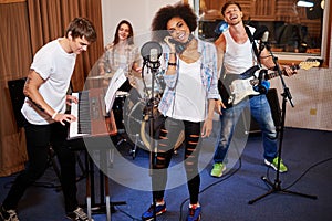 Multiracial music band performing in a recording studio