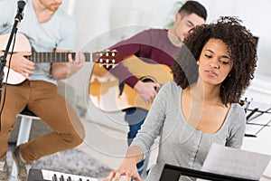 Multiracial music band performing in recording studio