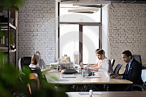 Diverse employees busy working in shared office photo