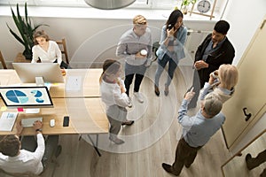 Multiracial office people of different age working talking, top