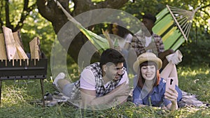 Multiracial peopel with mobile and drinks on picnic