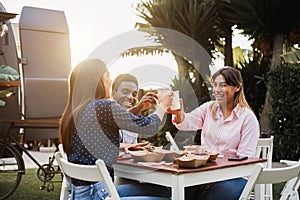 Multiracial people eating and cheering at food truck restaurant outdoor - Focus on african man face