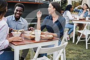 Multiracial people eating at food truck restaurant outdoor - Focus on african man face