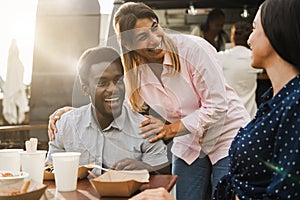 Multiracial people eating at food truck restaurant outdoor - Focus on center woman face