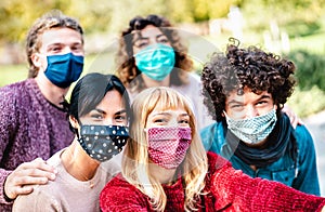 Multiracial people taking selfie wearing face mask and spring clothes - New normal lifestyle concept with young friends having fun