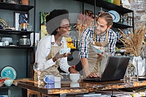 Multiracial people working on laptop during inventory