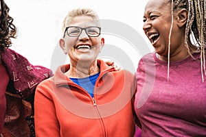 Multiracial senior women having fun together after sport workout outdoor - Focus on center woman face