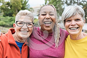 Multiracial senior women having fun together after sport workout outdoor - Focus on right female face