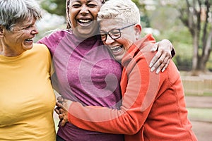 Multiracial senior women having fun together after sport workout outdoor - Main focus on right female face