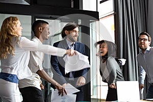 Multiracial staff screaming with joy dancing having fun at workplace