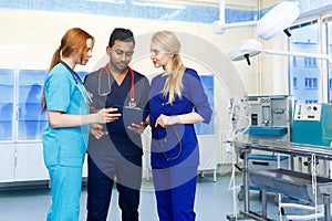 Multiracial team of doctors discussing a patient standing in a operating room