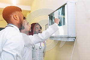 Multiracial team of young doctors looking at x-ray healthcare, medical and radiology concept