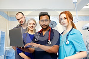 Multiracial team of young doctors working on laptop computer in medical office.