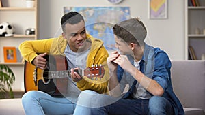 Multiracial teenage friends playing guitar and mouthorgan hobby musician career