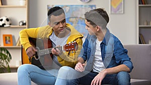 Multiracial teenage friends preparing for contest playing guitar musician career