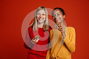 Multiracial two girls laughing while posing with cookies