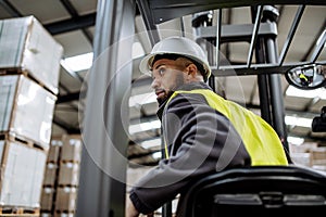 Multiracial warehouse worker driving forklift. Warehouse worker preparing products for shipmennt, delivery, checking