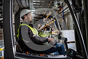 Multiracial warehouse worker driving forklift. Warehouse worker preparing products for shipmennt, delivery, checking