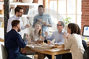 Multiracial work team eating pizza together on break