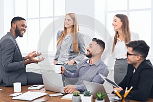 Multiracial work team tlking during coffee break