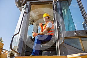 Manual worker driving cargo truck in plant