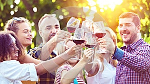 Multiracial young friends enjoying harvest time together at farm house winery drinking red wine