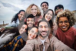 Multiracial young group of happy people taking selfie together