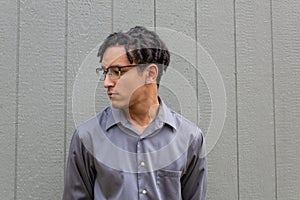 Multiracial young man in eyeglasses, profile view with natural hair in dreadlock twists, serious demeanor,