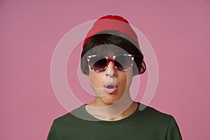 Multiracial young man, teenager 17s posing wearing Great Britain sunglasses print, red hat, khaki t-shirt isolated on