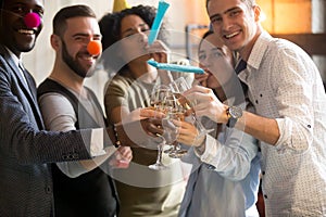 Multiracial young people clinking glasses blowing whistles celeb