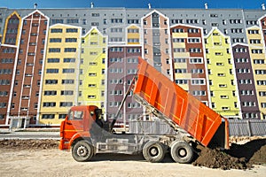 Multistorey building apartment house and dump truck unload soil