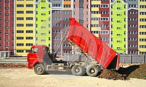Multistorey building apartment house and dump truck unload soil photo