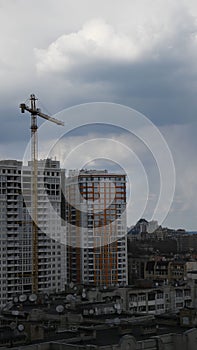 Multistorey building with construction crane jib against overcast sky