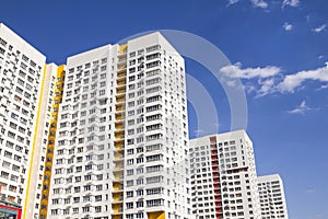 Multistory new modern apartment building against the blue sky. Stylish living block of flats. Newly built block of flats