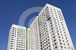 Multistory new modern apartment building against the blue sky. Stylish living block of flats. Newly built block of flats