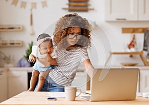 Multitasking african american self-employed mother working with baby from home on maternity leave