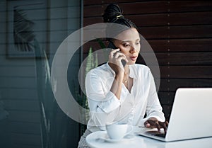 A multitasking businesswoman is powerful. an attractive young businesswoman sitting in the office and using her laptop