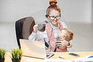 Businesswoman working with her baby son at the office