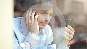 Multitasking at its finest. 4k video footage of a young businessman making a phone call while using his digital tablet.