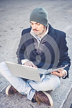 Multitasking man using tablet, laptop and cellhpone
