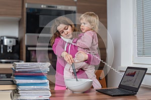 Multitasking mother is babysitting and working at home